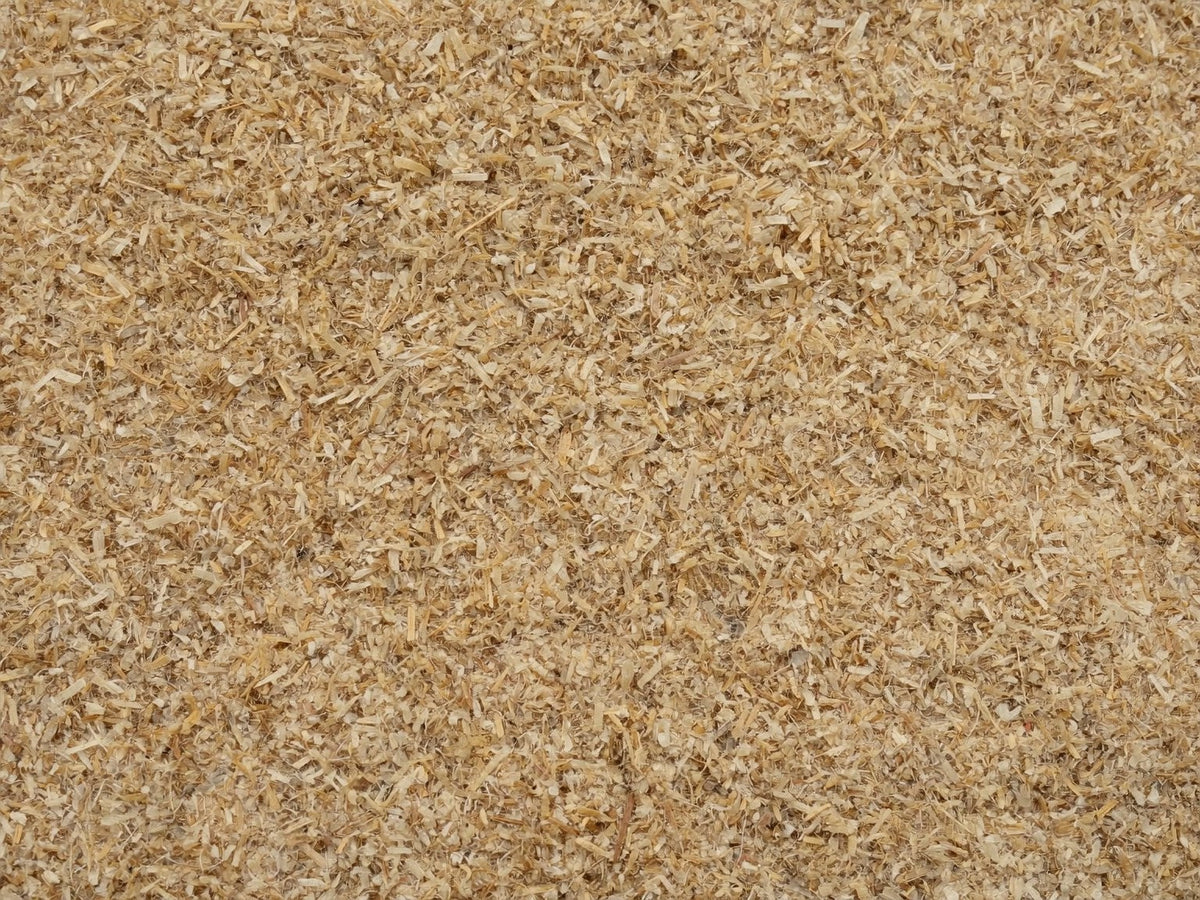 Close overhead view of coarse pale hemp hurd bedding filling the frame
